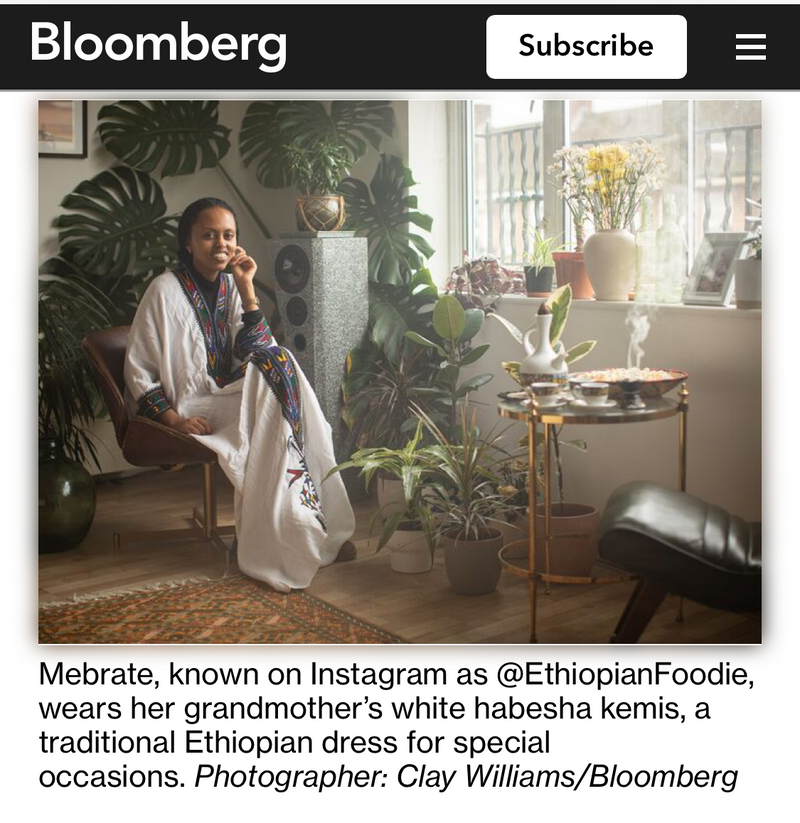Bloomberg article on a computer screen with text and a photo of a woman in a white dress.